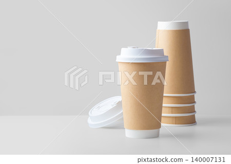 Disposable paper takeaway coffee cups on grey background 140007131