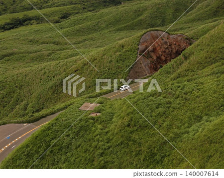 Aerial photograph of a mountain road running through the green volcanic hills of Minami Aso, Kumamoto Prefecture. Aerial photograph of a mountain road running through the green volcanic hills of Minami Aso, Kumamoto Prefecture. 140007614