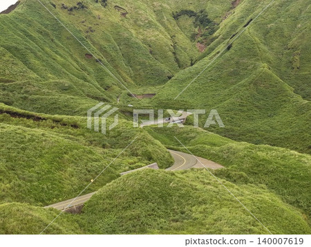 Aerial photograph of a winding road that winds through the green mountainside of Minami Aso, Kumamoto Prefecture. 140007619