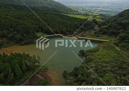 An aerial photograph overlooking a dam lake surrounded by forests in Minami-Aso, Kumamoto Prefecture. 140007622