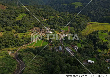 An aerial photograph overlooking a mountain village and rice paddies in Nobeoka City, Miyazaki Prefecture. An aerial photograph overlooking a mountain village and rice paddies in Nobeoka City, Miyazaki Prefecture. 140007654