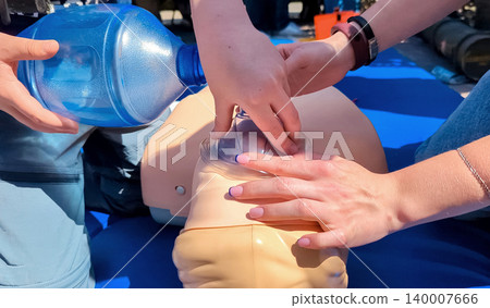 Children learning first aid during cpr training on a medical mannequin. Kids practicing artificial ventilation using an ambu bag resuscitator. Children learning first aid during cpr training on a medical mannequin. Kids practicing artificial ventilation using an ambu bag resuscitator. 140007666