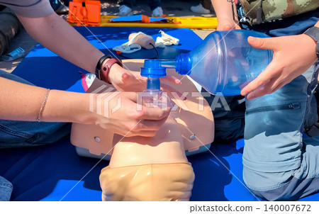 Children learning first aid during cpr training on a medical mannequin. Kids practicing artificial ventilation using an ambu bag resuscitator. Children learning first aid during cpr training on a medical mannequin. Kids practicing artificial ventilation using an ambu bag resuscitator. 140007672