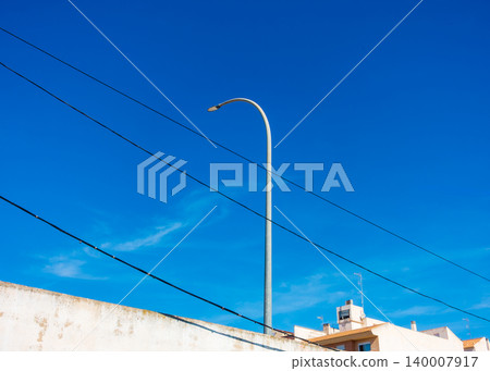Street Lamp with Electrical Wires and Residential Buildings Under Sky 140007917