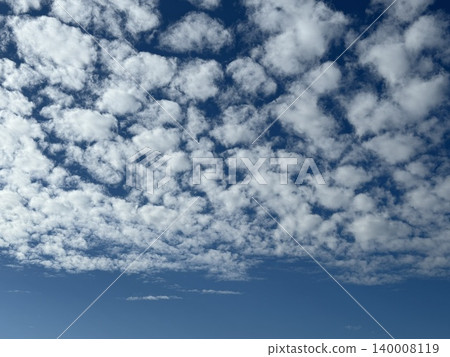 Beautiful fluffy clouds scattered across clear blue sky creating a serene and peaceful background 140008119