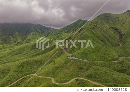 Aerial photograph of a winding mountain road running through the green mountains of Minami Aso, Kumamoto Prefecture. 140008528