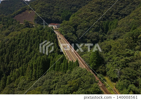 An aerial photograph overlooking a railway bridge spanning a deep green valley in Hinokage Town, Kumamoto Prefecture. An aerial photograph overlooking a railway bridge spanning a deep green valley in Hinokage Town, Kumamoto Prefecture. 140008561