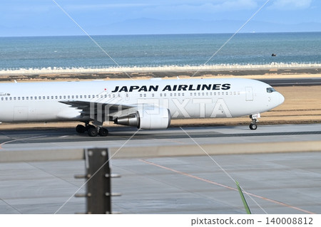 A Japan Airlines passenger plane with a beautifully shining white fuselage. A Japan Airlines passenger plane with a beautifully shining white fuselage. 140008812
