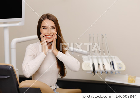 Woman is happy with results for oral hygiene and teeth whitening at dentist. Patient is smiling at the camera after tooth cleaning Woman is happy with results for oral hygiene and teeth whitening at dentist. Patient is smiling at the camera after tooth cleaning 140008844