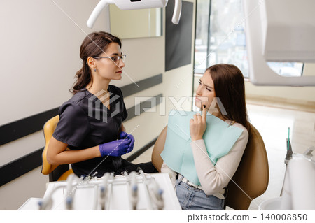 Young woman experiencing pain and anxiety while having a dental procedure performed on her Young woman experiencing pain and anxiety while having a dental procedure performed on her 140008850
