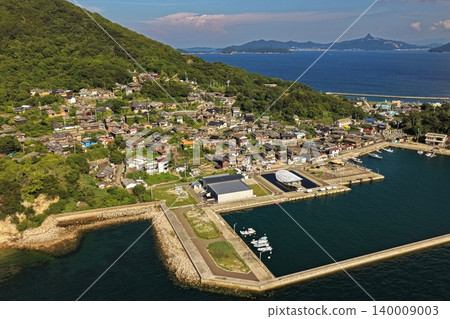 An aerial photograph overlooking the fishing village and harbor on Ogijima Island in Kagawa Prefecture. An aerial photograph overlooking the fishing village and harbor on Ogijima Island in Kagawa Prefecture. 140009003