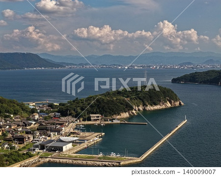 An aerial photograph overlooking the port of Ogijima Island in Kagawa Prefecture and the Seto Inland Sea. An aerial photograph overlooking the port of Ogijima Island in Kagawa Prefecture and the Seto Inland Sea. 140009007