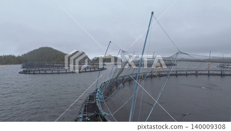 Large fish farm in the water with nets under cloudy sky as background Large fish farm in the water with nets under cloudy sky as background 140009308
