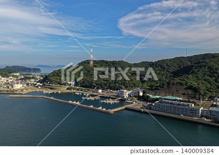 從對角視角拍攝的空拍照片,顯示了大分縣嵯峨關市的漁港和港口區域。 從對角視角拍攝的空拍照片,顯示了大分縣嵯峨關市的漁港和港口區域。 140009384