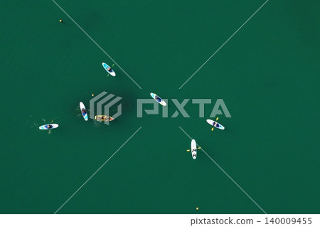 Aerial photograph of people enjoying SUP and kayaking in the green sea of Usuki City, Oita Prefecture. Aerial photograph of people enjoying SUP and kayaking in the green sea of Usuki City, Oita Prefecture. 140009455