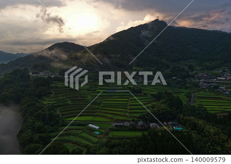 從空中俯瞰熊本縣日之影町的梯田和雲霧繚繞的山脈。 從空中俯瞰熊本縣日之影町的梯田和雲霧繚繞的山脈。 140009579