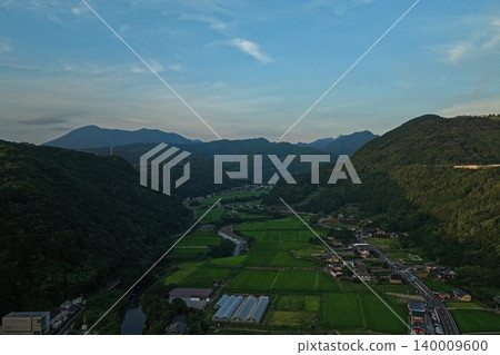 An aerial photograph taken at sunset over the mountainous basin and rice paddies of Omura City, Nagasaki Prefecture. An aerial photograph taken at sunset over the mountainous basin and rice paddies of Omura City, Nagasaki Prefecture. 140009600