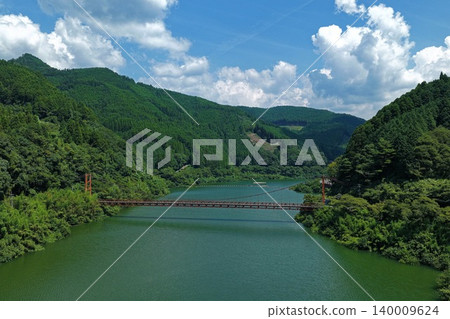 An aerial photograph overlooking the suspension bridge over the Hyugami Dam Lake in Yame City, Fukuoka Prefecture. An aerial photograph overlooking the suspension bridge over the Hyugami Dam Lake in Yame City, Fukuoka Prefecture. 140009624