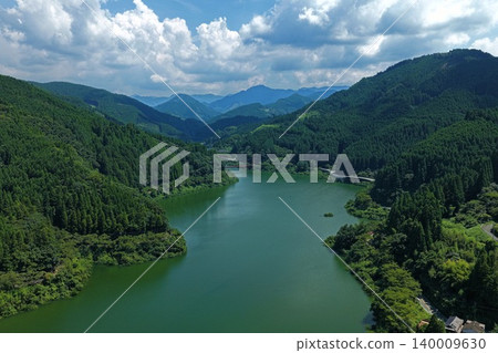 An aerial photograph overlooking the Hyugami Dam and the surrounding green mountains in Okuyame, Yame City, Fukuoka Prefecture. An aerial photograph overlooking the Hyugami Dam and the surrounding green mountains in Okuyame, Yame City, Fukuoka Prefecture. 140009630