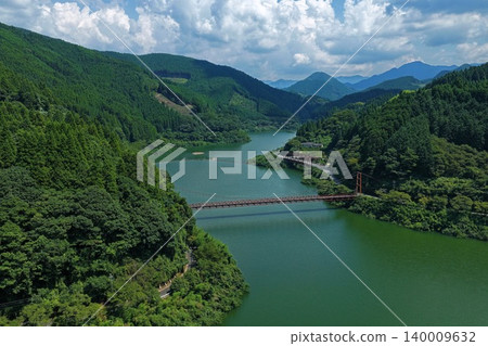 An aerial photograph overlooking the Hyugami Dam Lake and suspension bridge in Yame City, Fukuoka Prefecture. An aerial photograph overlooking the Hyugami Dam Lake and suspension bridge in Yame City, Fukuoka Prefecture. 140009632