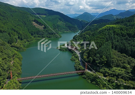 An aerial photograph overlooking the Hyugami Dam and suspension bridge in Yame City, Fukuoka Prefecture. An aerial photograph overlooking the Hyugami Dam and suspension bridge in Yame City, Fukuoka Prefecture. 140009634