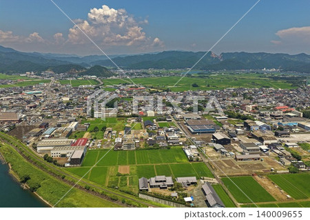 一張空拍照片，顯示了宮崎縣延岡市的城區、稻田和河流。 140009655