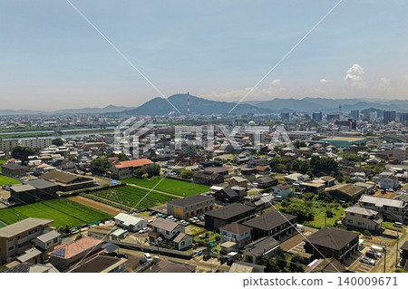 空拍照片，展現了宮崎縣延岡市的城區、稻田和山脈。 140009671