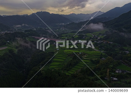黃昏時分，從空中拍攝的宮崎縣日之影町梯田和紅色拱橋的景象。 140009699