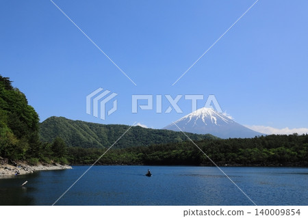 一艘小船靜靜地滑過西湖,周圍環繞著蔥鬱的綠植,遠處是白雪皚皚的富士山。 一艘小船靜靜地滑過西湖,周圍環繞著蔥鬱的綠植,遠處是白雪皚皚的富士山。 140009854