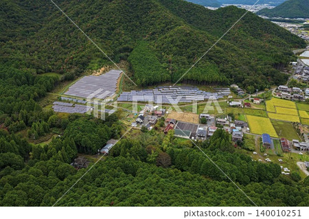 Aerial photograph of solar power facilities and settlements spread across the mountainous area of Taka District, Hyogo Prefecture. Aerial photograph of solar power facilities and settlements spread across the mountainous area of Taka District, Hyogo Prefecture. 140010251