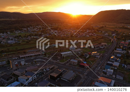 An aerial photograph capturing the townscape and mountain range of Kamikawa, Hokkaido, at dusk. An aerial photograph capturing the townscape and mountain range of Kamikawa, Hokkaido, at dusk. 140010276