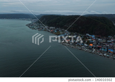 一張從傾斜角度拍攝的空拍照片，顯示了北海道厚岸市的一個漁村和海岸線。 140010302