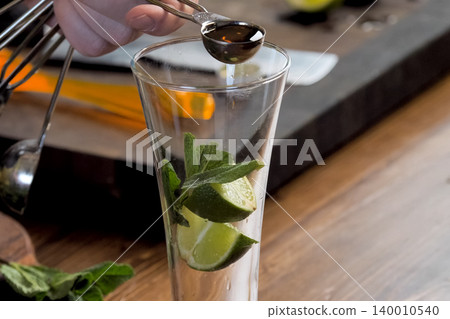 making cocktail of mint and lemon. making cocktail of mint and lemon. 140010540