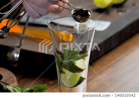making cocktail of mint and lemon. making cocktail of mint and lemon. 140010542