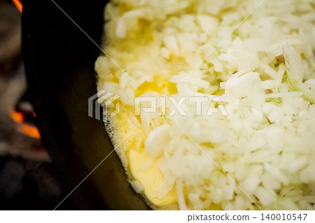 Roasting onions in pan with oil on fire. Roasting onions in pan with oil on fire. 140010547