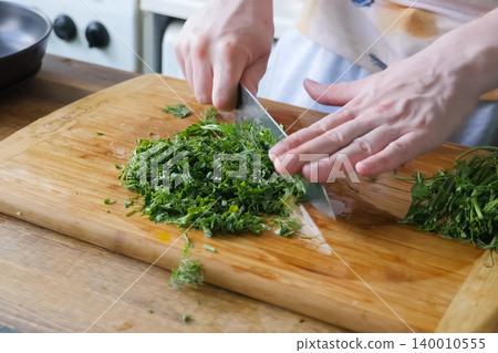 Sliced parsley and dill on board. Greens for the second course. Sliced parsley and dill on board. Greens for the second course. 140010555