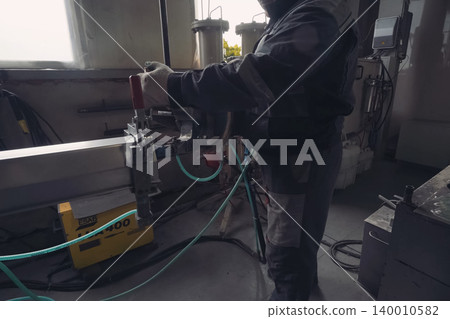 Worker works at a climatic equipment factory. Worker works at a climatic equipment factory. 140010582