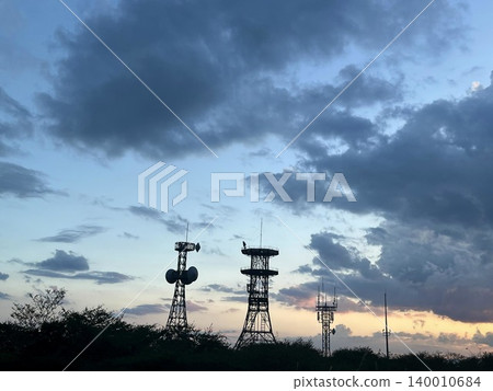 Steel tower floating in the sunset sky Steel tower floating in the sunset sky 140010684