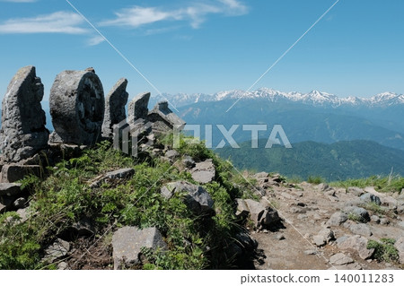 A refreshing mountain landscape overlooking stone Buddha statues and snow-capped mountain ranges. 140011283