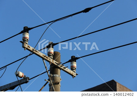 高壓輸電線路和電線桿上的白色絕緣子在藍天的襯托下格外醒目。 高壓輸電線路和電線桿上的白色絕緣子在藍天的襯托下格外醒目。 140012402