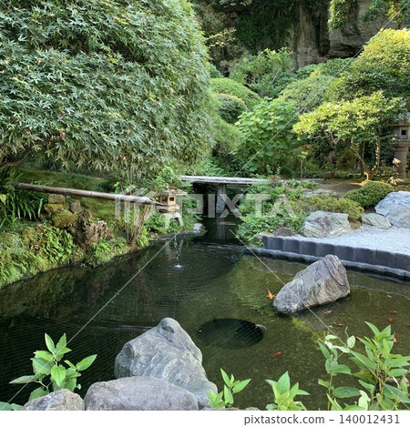 美麗的日式花園景觀,周圍綠樹環繞,池塘裡養著錦鯉(觀賞鯉魚)。 美麗的日式花園景觀,周圍綠樹環繞,池塘裡養著錦鯉(觀賞鯉魚)。 140012431