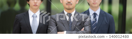 The image depicts a business team with a building in the background, featuring a bearded boss, CEO, and leader alongside younger employees, symbolizing organizational strength and talent development. 140012480