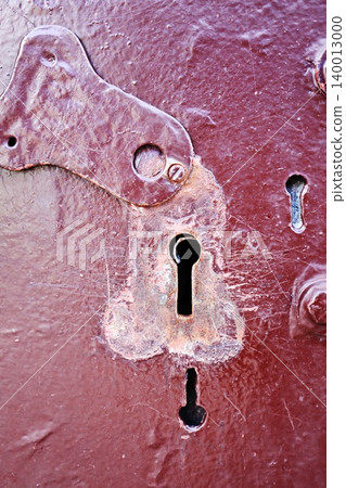 Antique Keyhole Escutcheon on Weathered Red Painted Door with Cobwebs, Atmospheric Vintage Hardware Detail 140013000