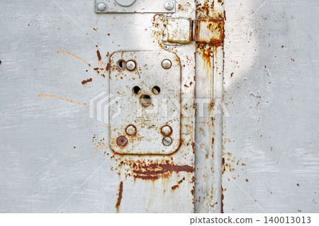 Gray Metal Door Panel with Rusted Latch Plate and Bolts, Weathered Industrial Hardware Detail Macro Gray Metal Door Panel with Rusted Latch Plate and Bolts, Weathered Industrial Hardware Detail Macro 140013013