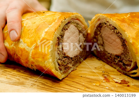 a Prepared meatloaf with dough roll cutting meatloaf. 140013199