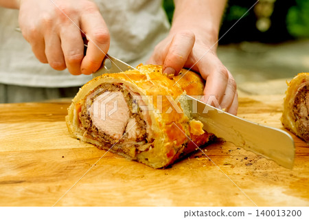 a Prepared meatloaf with dough roll cutting meatloaf. a Prepared meatloaf with dough roll cutting meatloaf. 140013200