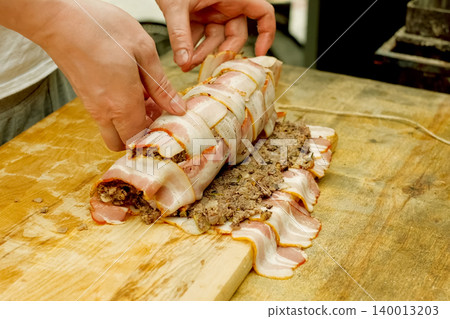 Folding raw meatloaf, cooking meatloaf. Folding raw meatloaf, cooking meatloaf. 140013203