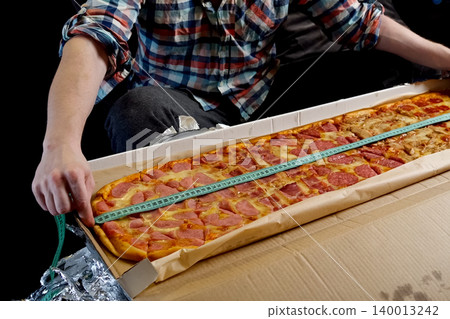 Measure pizza length with a tape measure Measure pizza length with a tape measure 140013242