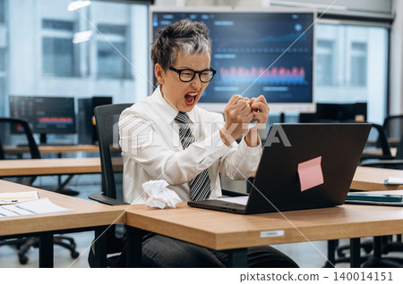 Business professional expressing frustration while working on a laptop in a modern office environment, showcasing the challenges of corporate life and stress management Business professional expressing frustration while working on a laptop in a modern office environment, showcasing the challenges of corporate life and stress management 140014151