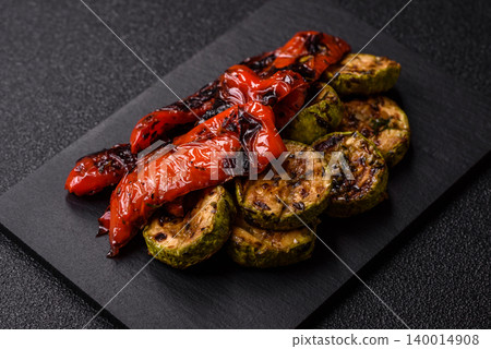 Grilled or barbecued sweet peppers and zucchini slices with salt. Grilled peppers and zucchini Grilled or barbecued sweet peppers and zucchini slices with salt. Grilled peppers and zucchini 140014908